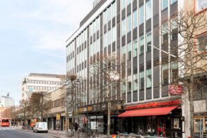 Fasad av en modern kontorsbyggnad på Västra Storgatan 12 i Jönköping, med butiker och restauranger i markplan.