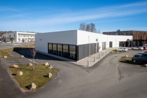 MÖTESPLATS KÄRNEKULLA, entré och parkering framför modern byggnad.